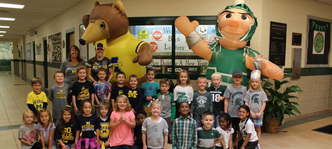 Students posing with Michigan and Michigan state mascots